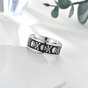 Close-up of vintage stainless steel skull ring with black lacquer on stone pedestal
