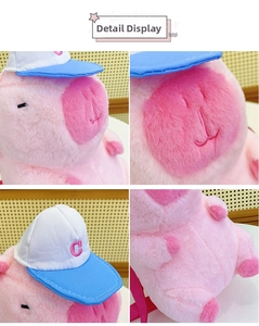 Detailed view of pink plush pig toy with blue baseball cap and red C embroidery