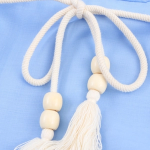Blue vacation dress detail featuring braided cotton waist rope with wooden beads and tassels