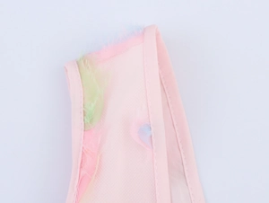 Close-up of pink mesh dress featuring delicate colorful floral fuzz and neat stitching