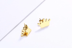 Detailed close-up of golden crown stud earrings showing polished metal and butterfly backs