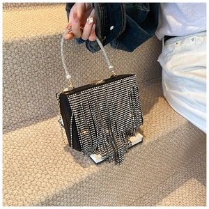 Detail of luxury black evening bag with silver rhinestone tassels and pearl handle