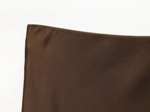 Macro detail of dark brown satin midi skirt fabric showing smooth silk texture and sheen