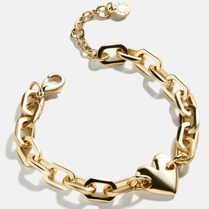 Close-up of golden stainless steel heart pendant on a chunky chain necklace