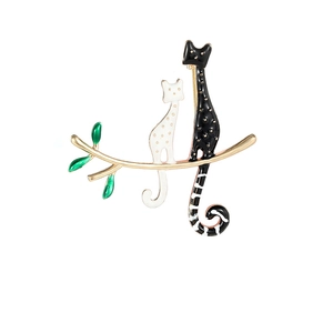 Cute black and white enamel cats on a golden branch brooch with green leaves