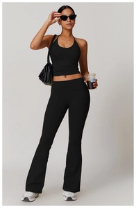 Detail of black halter yoga set featuring high waist flared pants and cropped tank top