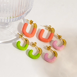 Macro shot of colorful U-shaped enamel earrings in orange green and pink tones