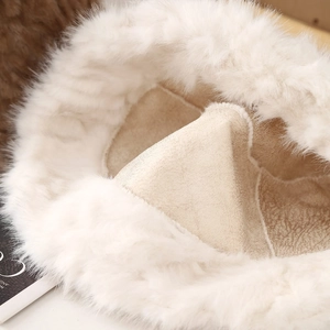 Detail of white faux fur bucket hat showing soft plush texture and premium suede lining