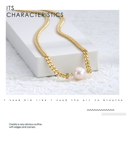 Detailed shot of a gold Cuban chain necklace with a lustrous pink pearl on a stone base