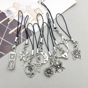 Close-up of vintage silver alloy spider and moon charms with black lanyards for DIY jewelry