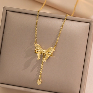 Golden bow heart pendant necklace in titanium steel on a soft jewelry display box