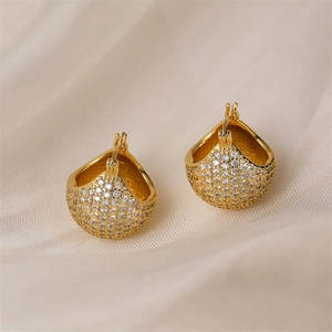 Close-up of gold-plated hoop earrings with micro-pave crystals on beige silk