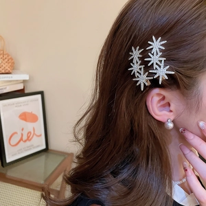 Close-up of sparkling rhinestone star hairpins on hair with elegant metal base
