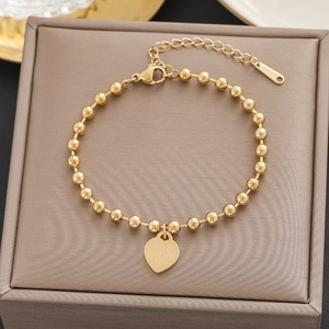 Detail of gold bead bracelet with heart pendant engraved with LOVE FOREVER 520