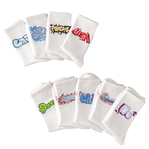 White crew socks with colorful graffiti letters and ribbed texture on white background