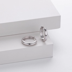Close-up of S925 sterling silver stamp on minimalist polished hollow hoop earrings