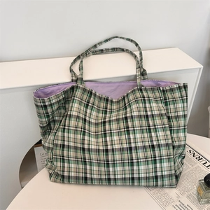 Close-up of a checkered tote bag with green and black patterns and purple lining detail