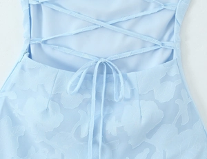 Détail de la robe bleu clair montrant le laçage au dos et la texture jacquard florale