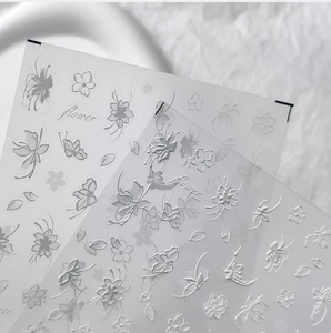 Detailed macro of 5D embossed white flower nail stickers with 3D floral textures