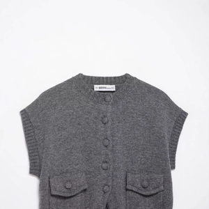 Gilet en maille gris pour femmes avec boutons décoratifs, vue à plat sur fond blanc épuré