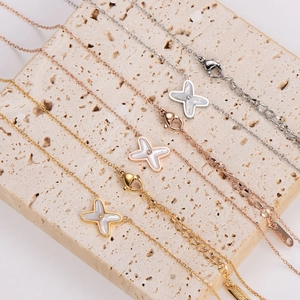 Three minimalist 18K gold plated cross star necklaces with white shell inlay in a parallel layout