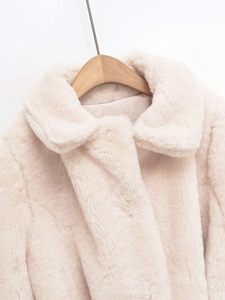 Detail of lapel and plush faux fur texture on elegant cream white winter coat