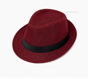Detail view of burgundy straw jazz fedora hat with a black ribbon band and classic crown