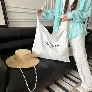 Detail of a large white canvas tote bag with black Sunday Summer Night Pajama print