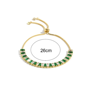 Detail of adjustable gold bracelet with green emerald cut and clear cubic zirconia stones
