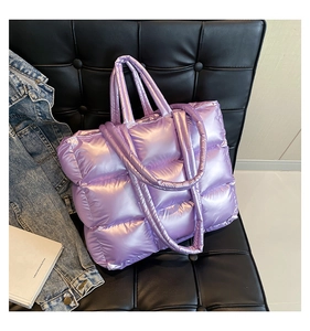 Dettaglio della borsa tote trapuntata viola con trama a sbuffo su una sedia nera