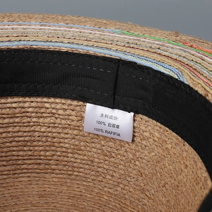 Detail view of 100% natural raffia straw hat with inner sweatband and color stitching