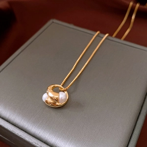 Close-up of 18k gold plated irregular pearl pendant necklace on a jewelry box