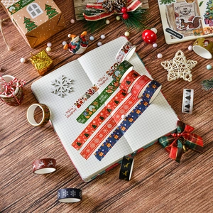 Flat lay of Christmas washi tape set with reindeer and snowflake patterns on wood
