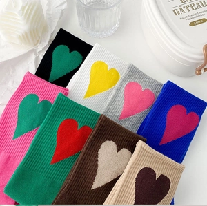 Close-up of ribbed cotton crew socks with contrast heart patterns in multiple pastel colors