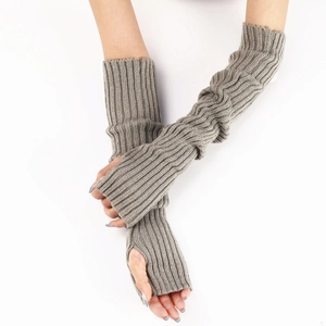 Detail of grey knitted arm warmers showing ribbed texture and fingerless design on a model
