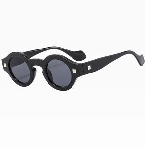 Detail of round black vintage sunglasses with silver square studs and wavy arms