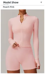 Detail of peach pink zip-up fitness top with thumbholes and matching biker shorts