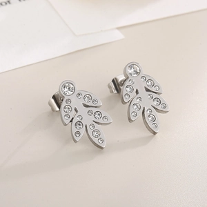 Detailed view of leaf-shaped silver stud earrings with sparkling white crystals
