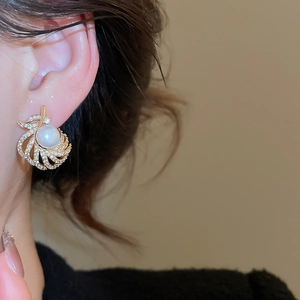 Close-up of 18k gold plated pearl drop earrings with crystal accents on ear