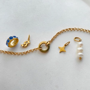 Detailed view of DIY titanium steel bracelet charms featuring pearls, stars, and blue rhinestones.