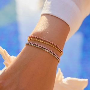Gros plan d'un ensemble de bracelets multicouches en acier inoxydable et zircon rose
