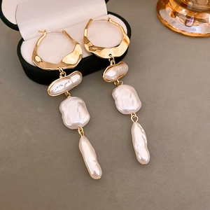 Vintage Baroque irregular pearl tassel earrings with gold metal rings on a jewelry box