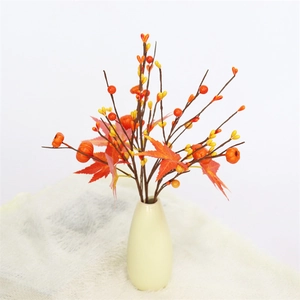 Autumn artificial pumpkin and maple leaf branch in a white ceramic vase for fall decor