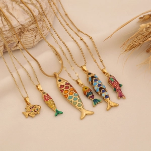 Set of six gold stainless steel necklaces with colorful enamel fish pendants on stone