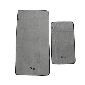 Flat lay of gray microfiber pet towels with black trim and decorative paw prints