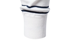 Macro view of ribbed cuffs and navy stripes on a white knit sweater for men