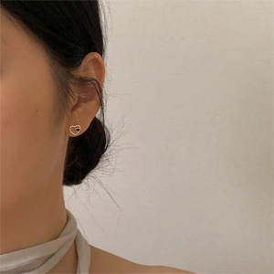 Minimalist 925 sterling silver heart stud earrings with golden finish on model