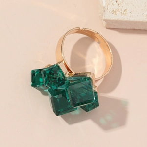 Anello d'oro elegante con cristalli verde smeraldo su una fascia lucida semplice