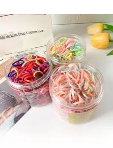 Detailed view of three colorful jars filled with elastic hair bands for kids