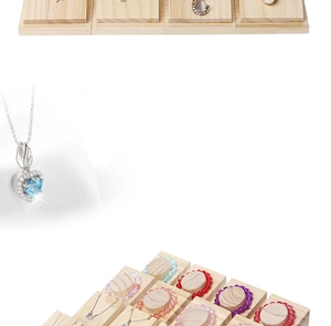Detail of wooden jewelry display block featuring colorful beaded bracelets and heart necklace
